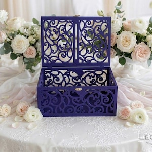 May include: A deep purple rectangular wooden box featuring an intricate laser-cut filigree pattern on the lid and sides. The box has an open top, a hinged lid, and a small gold-colored metal latch on the front. The text Leonarts is visible.