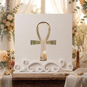 May include: A square white wooden display board featuring a central cutout in the shape of an ankh symbol. The base of the board is decorated with white scrollwork patterns. The logo LEONARTS is visible in the top left corner of the image.