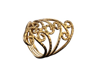 May include: A gold ring featuring a delicate, intricate design of swirling lines and curves. The ring is crafted from textured metal and has a wide band.