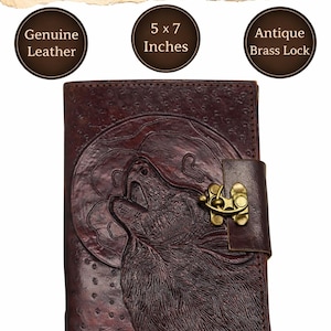 May include: A dark brown leather journal with an embossed wolf and moon design. The journal is 5 x 7 inches and features an antique brass lock. The cover is made of genuine leather.