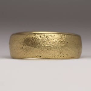May include: A gold band ring with a textured, hammered finish.