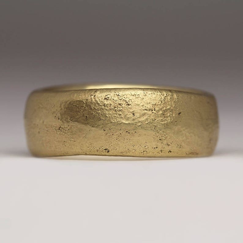 May include: A gold band ring with a textured, hammered finish.