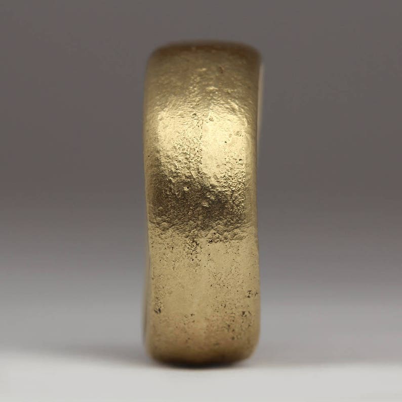 May include: A simple gold band ring with a smooth, slightly textured surface.