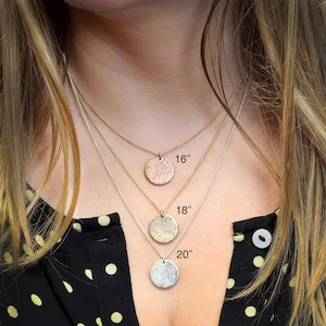 May include: Three silver necklaces with different length chains and textured round pendants. The chains are 16 inches, 18 inches, and 20 inches long.