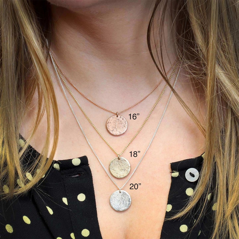May include: Three silver necklaces with different length chains and textured round pendants. The chains are 16 inches, 18 inches, and 20 inches long.