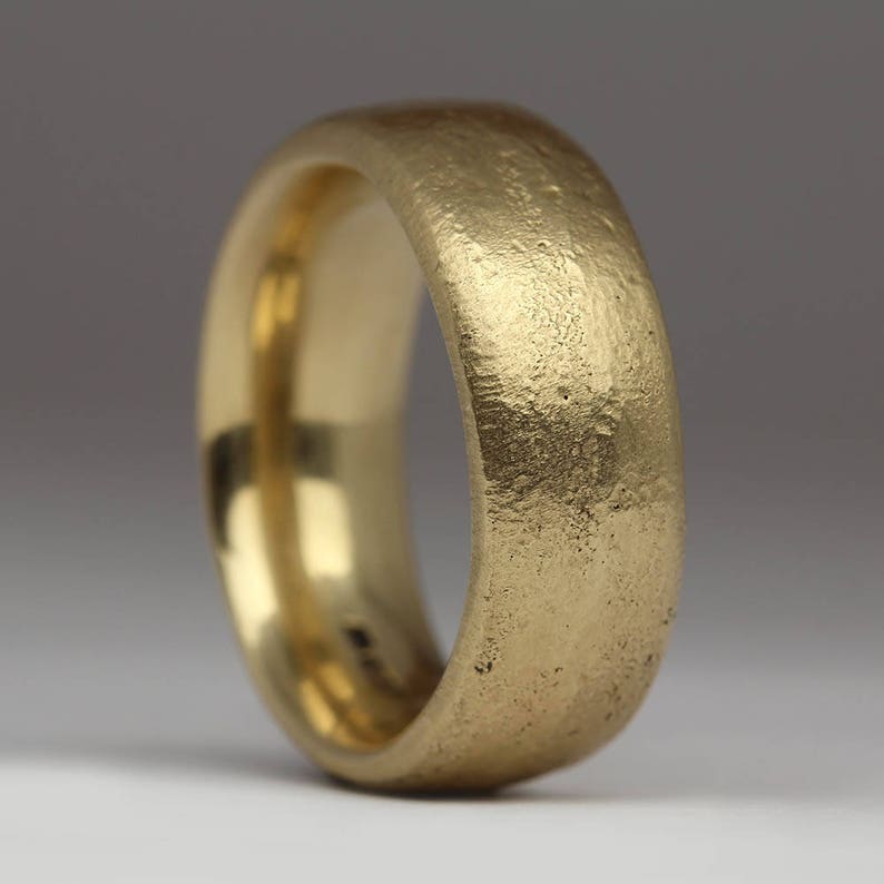 May include: A gold wedding band with a textured, hammered finish.
