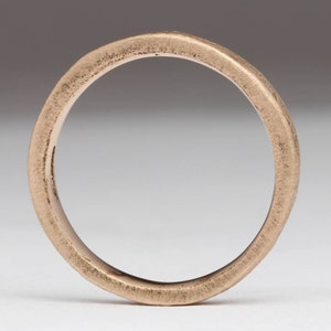 May include: A simple, brushed gold band ring.