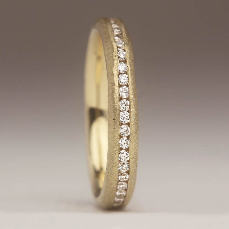 May include: A gold band with a row of small diamonds set into the metal.