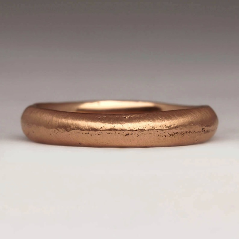 Op de afbeelding: Een eenvoudige, geborstelde ros&eacute;gouden trouwring. De ring is glad en heeft een licht afgerond profiel.