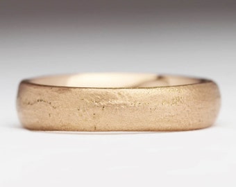 Op de afbeelding: Een eenvoudige gouden trouwring met een geborstelde afwerking.