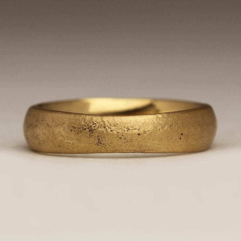 May include: A simple gold wedding band with a textured finish.