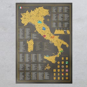 May include: A rectangular wall poster featuring a detailed map of Italy in gold on a dark gray background. The map includes labeled regions, cities, and landmarks, with lists of locations and small gold-colored crests displayed along the right side.