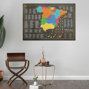 Puede incluir: Un mapa enmarcado de España con fondo negro y regiones coloridas. El mapa incluye la palabra "España" en la parte superior y varias listas y símbolos. El marco es negro con un borde dorado. El mapa está colgado en una pared blanca.