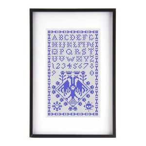May include: Framed cross-stitch sampler with a black frame. The design features a blue alphabet, numbers, and decorative elements, including birds. The sampler is a traditional craft piece, perfect for home decor.