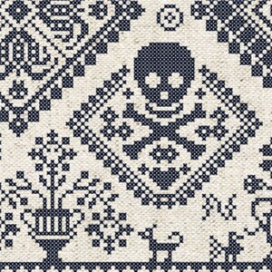May include: A detailed cross-stitch pattern in navy blue on an off-white background. The design features geometric shapes, floral motifs, and a central skull and crossbones symbol. The overall aesthetic is reminiscent of traditional folk art.