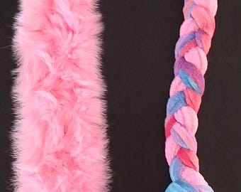 May include: A pink and multi-colored braided rope dog toy with a pink fluffy tail. The rope is braided with pink, blue, and purple fabric.