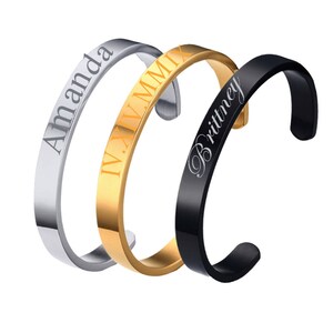 May include: Three personalised bracelets, one silver with the name "Amanda", one gold with Roman numerals, and one black with the name "Brittney".