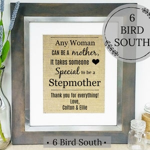 Puede incluir: Una impresi&oacute;n enmarcada en tela de arpillera con el texto "Any Woman Can Be A Mother, It Takes Someone Special To Be A Stepmother. Thank You For Everything! Love, Colton & Ellie." El marco es de madera marr&oacute;n con un paspart&uacute; plateado. La impresi&oacute;n es de 6 Bird South.