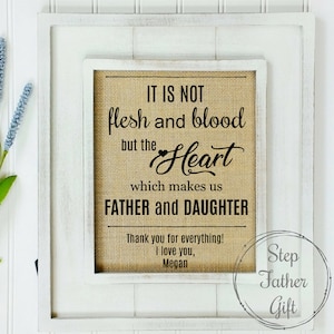 May include: A white framed burlap sign with the text "IT IS NOT flesh and blood but the Heart which makes us FATHER and DAUGHTER" and a small heart symbol. The sign also includes the text "Thank you for everything! I love you, Megan" and a circle with the text "Step Father Gift".