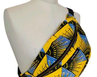 May include: A yellow, blue, and black fan-shaped patterned fanny pack with a black zipper and a black strap. The fanny pack is on a white mannequin. The text "Jenny Polly" is printed on the fanny pack.