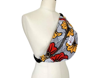 May include: A floral print fanny pack with a black strap and zipper. The bag features a white background with red, yellow, and black floral patterns. The bag is displayed on a mannequin.
