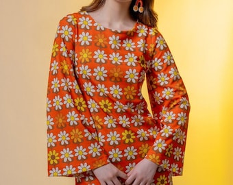 Minivestido naranja estampado de margaritas corte en A y mangas acampanadas.