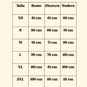 Puede incluir: Una tabla de tallas con el t&iacute;tulo "Gu&iacute;a de tallas" en una fuente retro. La tabla enumera las tallas XS a 3XL con medidas de busto, cintura y cadera en cent&iacute;metros. El fondo es de color beige claro.