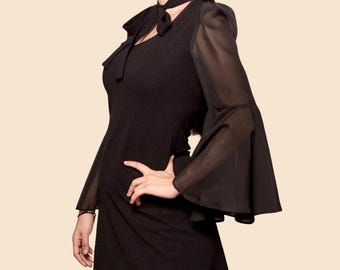Minivestido negro con mangas acampanadas y corbata de moño estilo 60s y 70s. Elegante y atemporal.
