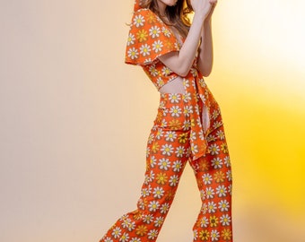 Pantalones de pierna ancha y cintura alta color naranja estampados de margaritas.