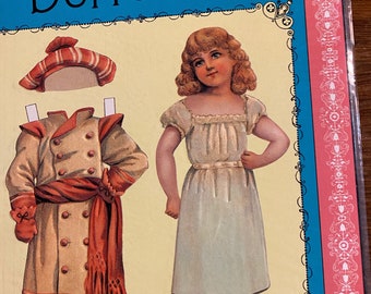 May include: A vintage paper doll set featuring a girl wearing a white dress and a boy wearing a red and white hat and a brown coat. The paper dolls are on a yellow background with a blue border.