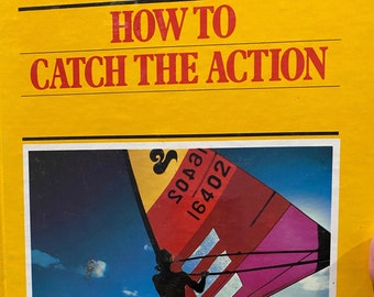 Pode incluir: Um livro intitulado "How to Catch the Action" da Biblioteca Kodak de Fotografia Criativa. A capa apresenta uma imagem colorida de uma pessoa a fazer windsurf num corpo de água azul brilhante.
