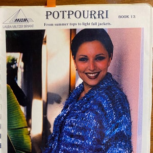May include: A woman wearing a blue and white fuzzy knit cardigan. The cardigan has a loose fit and a slightly cropped length. The woman is smiling and looking at the camera. The image is from a book titled "Potpourri, Book 13: From summer tops to light fall jackets."