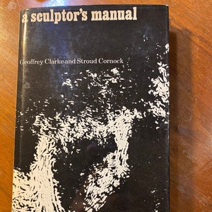 May include: A book titled "a sculptor's manual" with a black cover and white text. The cover features a white abstract design. The authors' names, Geoffrey Clarke and Stroud Cornock, are also printed on the cover.