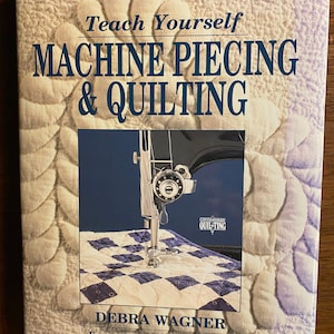 May include: Book cover with a white background and a sewing machine stitching a quilt. The title is "Teach Yourself Machine Piecing & Quilting" by Debra Wagner with a foreword by Robbie Fanning.