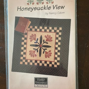 May include: A quilting pattern for a Honeysuckle View quilt, designed by Nancy Odom. The pattern features a black and white checkered border with a central block featuring a stylized honeysuckle flower design in red, brown, and white. The pattern is from Timid Thimble Creations.