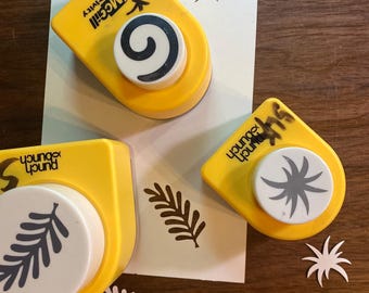 May include: Three yellow McGill Craftivity and Punch Bunch paper punches with white circular plungers. The tools feature black printed text and create die-cut shapes including a spiral, a fern-like leaf, and a starburst pattern on white paper.