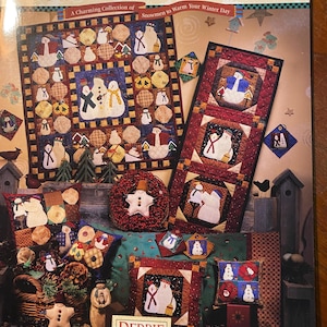 Może przedstawiać: Okładka książki przedstawiająca kolekcję pikowanych wzorów bałwanów. Tytuł książki to "Frosty Folks: A Charming Collection of Snowmen to Warm Your Winter Day". Okładka przedstawia różne wzory bałwanów, w tym dużego bałwana z czerwonym szalikiem i mniejszego bałwana z niebieskim szalikiem. Książka jest autorstwa Debbie Mumm.