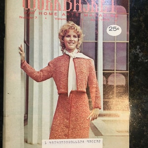 Könnte beinhalten: Das Cover des Workbasket and Home Arts Magazine, auf dem eine Frau in einer rosa Strickjacke und einem Rock zu sehen ist, mit dem Text "The Workbasket and Home Arts Magazine" und "25c" auf dem Cover.