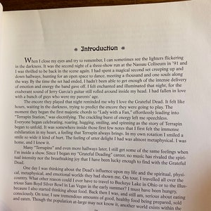 Puede incluir: Una portada de libro con una foto en blanco y negro de una persona en un escenario con un micr&oacute;fono. El t&iacute;tulo del libro es "Introducci&oacute;n" y el texto de la portada describe la experiencia del autor en un concierto de Grateful Dead.
