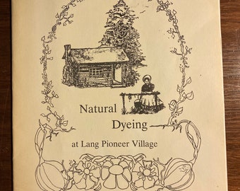 May include: A black and white illustration of a cabin with a tree and a person sitting on a bench. The text "Natural Dyeing at Lang Pioneer Village" is below the image.