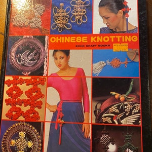 Puede incluir: Un libro de tapa dura titulado Chinese Knotting de Echo Craft Books. La portada presenta una cuadrícula de fotografías que muestran varios diseños intrincados de nudos, borlas decorativas y una persona con una blusa rosa y falda azul.