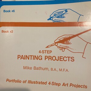 May include: A stack of three art instruction books. The top book is labeled "Book #7" and the bottom book is labeled "Book #2". The books feature illustrations of hands holding pens and paintbrushes, with the title "4-STEP PAINTING PROJECTS".