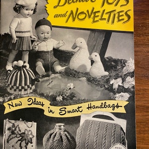 May include: A vintage knitting pattern booklet titled "Beehive Toys and Novelties" priced at 50 pence. The cover features illustrations of knitted toys, including a doll, a boy, two ducks, and a basket. The booklet also includes a section on "New Ideas in Smart Handbags" with illustrations of three knitted handbags.