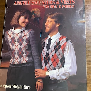 Puede incluir: Una portada de libro vintage con una pareja modelando suéteres y chalecos argyle de ganchillo. El texto de la portada dice "CROCHETED ARGYLE SWEATERS & VESTS FOR MEN & WOMEN" y "In Sport Weight Yarn by Carole Rutter."