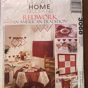 May include: McCall's Home Decorating Redwork: An American Tradition pattern for a red and white checkered tablecloth, a red and white checkered apron, and a red and white checkered wall hanging with a redwork apple design. The pattern includes instructions for embroidery and sewing.