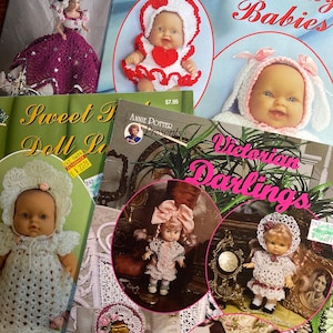 Puede incluir: Una colección de patrones de muñecas y muñecas vintage. Los patrones se titulan "Holiday Babies", "Sweet Dolls" y "Victorian Darlings". Las muñecas visten trajes de ganchillo, con gorros y vestidos en blanco, rosa y rojo.