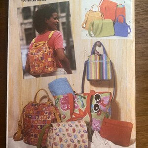 May include: Butterick sewing pattern 6043 featuring illustrations of various bags including a backpack with a colorful geometric tile print, a floral tote, a striped handbag, a solid orange pouch, and a leaf-print messenger bag with shoulder straps.