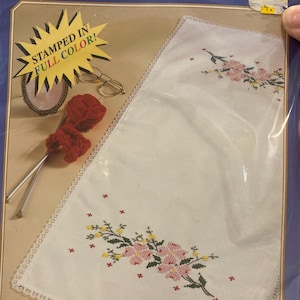 Op de afbeelding: Een wit geborduurd zakdoekje met een bloemenmotief in roze, geel en groen. Het zakdoekje heeft een delicate kanten rand en is verpakt in plastic. De verpakking bevat de tekst "STAMPED IN FULL COLOR!"