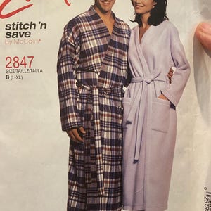 May include: A sewing pattern envelope for Easy stitch 'n save by McCall's, number 2847, size B (L-XL). The cover features two robes: one in a blue, white, and brown plaid pattern and another in solid light purple, both with long sleeves and belts.
