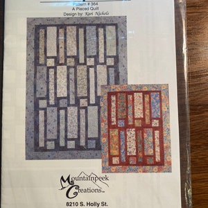 May include: A quilting pattern titled "9 Easy Pieces" with a design by Kari Nichols. The pattern is for a pieced quilt and features two different quilt block designs. The pattern is from Mountainpeek Creations, located at 8210 S. Holly St., Centennial, CO 80122. The phone number is 1-888-768-5922.